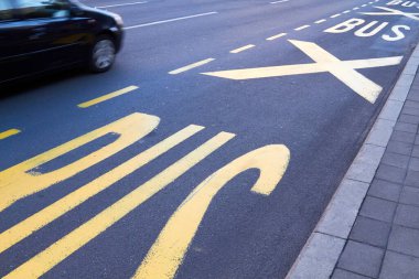Hareket halindeki araba ve otobüs trafiği için ayrılmış sarı bir toplu taşıma şeridi..