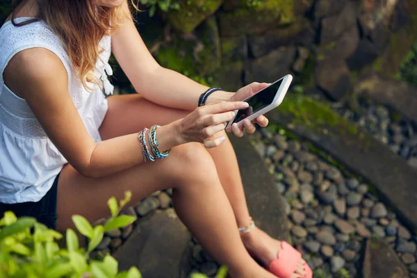 Doğu bahçesinde modern akıllı telefon kullanan beyaz bir kadın..