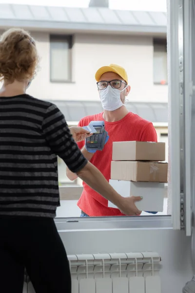 Repartidor Con Una Máscara Médica Con Paquetes Mujer Pagando Con — Foto de Stock