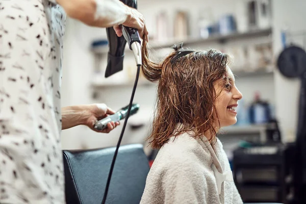 Hairdresser cutting hair in a salon.