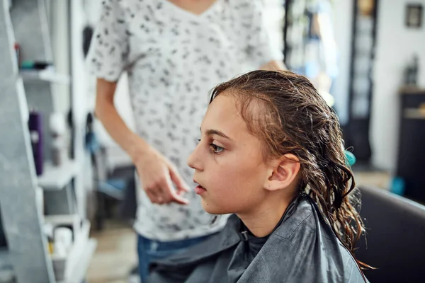 Hair dresser cutting hair in a salon.