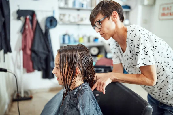 Hair dresser cutting hair in a salon.