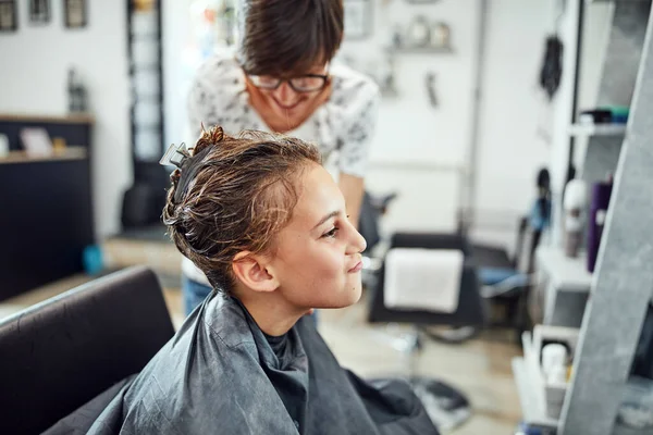 Hair dresser cutting hair in a salon.