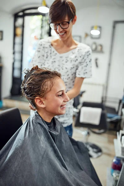 Hair dresser cutting hair in a salon.