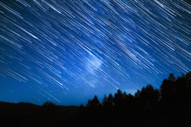 Samanyolu yıldızları kırsal bölgelerdeki siluetleri takip eder.