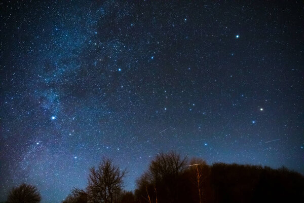 Milky way stars and rural countryside silhouettes.