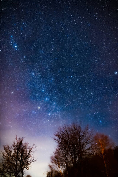 Milky way stars and rural countryside silhouettes.