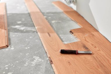 Yeni lamine ahşap döşeme monte ediliyor.