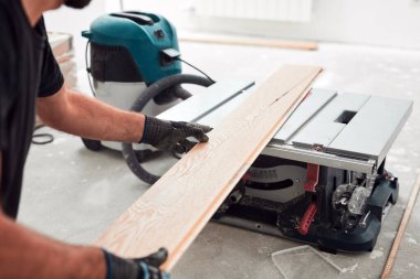 Profesyonel tamirci yeni bir daireye kaplama döşeme kuruyor..