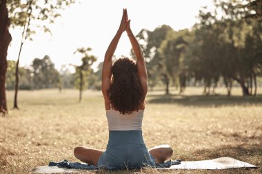 Sıcak bir yaz gününde parkta yoga ve esneme egzersizleri yapan bir kadın..