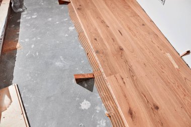 Profesyonel tamirci yeni bir daireye kaplama döşeme kuruyor..