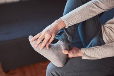 Ayak bileği ve ayak ağrısı olan bir adam..