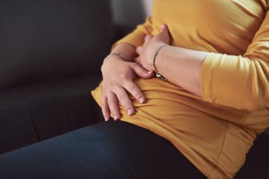 Güçlü karın ağrısı, regl ve sindirim sorunları olan bir kadın..