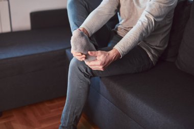 Ayak bileği ve ayak ağrısı olan bir adam..