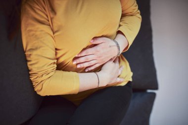 Güçlü karın ağrısı, regl ve sindirim sorunları olan bir kadın..