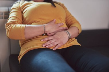 Güçlü karın ağrısı, regl ve sindirim sorunları olan bir kadın..