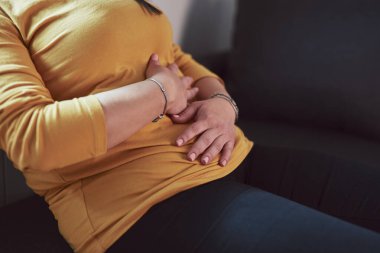 Güçlü karın ağrısı, regl ve sindirim sorunları olan bir kadın..