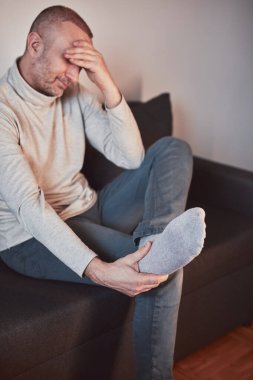 Ayak bileği ve ayak ağrısı olan bir adam..