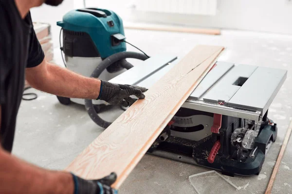 Profesyonel tamirci yeni bir daireye kaplama döşeme kuruyor..