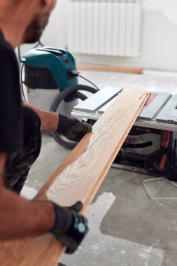 Profesyonel tamirci yeni bir daireye kaplama döşeme kuruyor..