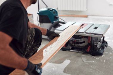 Profesyonel tamirci yeni bir daireye kaplama döşeme kuruyor..