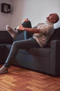 Ayak bileği ve ayak ağrısı olan bir adam..