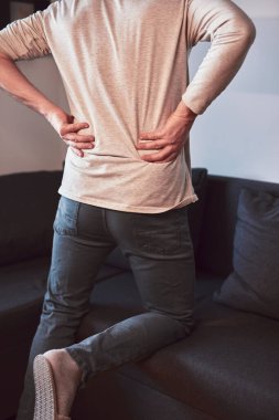 Kalçası, sırtı ve siyatik ağrısı olan bir adam..