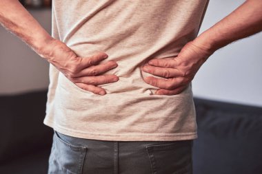 Kalçası, sırtı ve siyatik ağrısı olan bir adam..