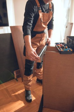 Marangoz yeni bir dairede çalışıyor ve mobilya monte ediyor..