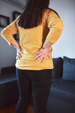 Kalçası, sırtı ve siyatik ağrısı olan bir kadın..