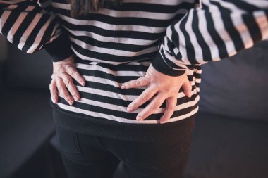 Kalçası, sırtı ve siyatik ağrısı olan bir kadın..