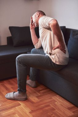 Kalçası, sırtı ve siyatik ağrısı olan bir adam..