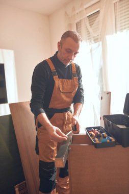 Marangoz yeni bir dairede çalışıyor ve mobilya monte ediyor..