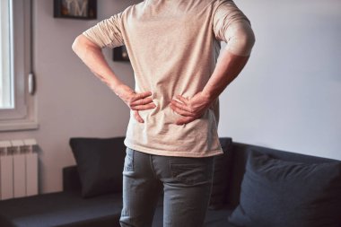 Kalçası, sırtı ve siyatik ağrısı olan bir adam..