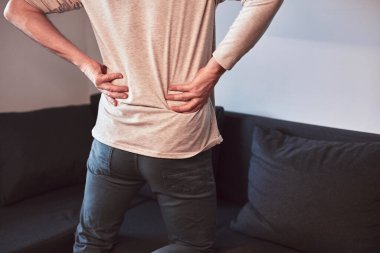 Kalçası, sırtı ve siyatik ağrısı olan bir adam..