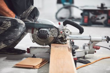 Profesyonel tamirci yeni bir daireye kaplama döşeme kuruyor..