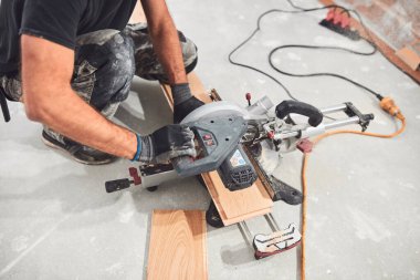 Profesyonel tamirci yeni bir daireye kaplama döşeme kuruyor..