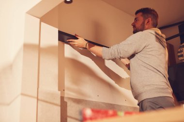 Tamirci mutfak dolaplarını ve rafları monte ediyor ve onarıyor..