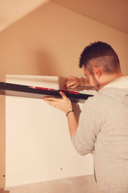 Tamirci mutfak dolaplarını ve rafları monte ediyor ve onarıyor..