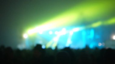 Sahne ışıkları olan, bulanık fotoğraflı konser kalabalığının siluetleri..