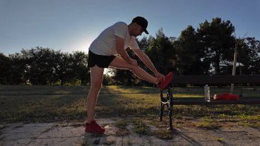 Adam spor yaptıktan ve parkta koştuktan sonra geriniyor..