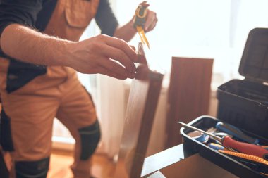 Marangoz yeni bir dairede çalışıyor ve mobilya monte ediyor..