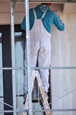 Tamirci yeni bir bina cephesinde çalışıyor..