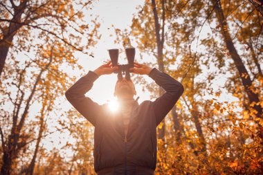 Kuşları ve diğer hayvanları dürbünle gözlemleyen amatör kuş gözlemcisi..