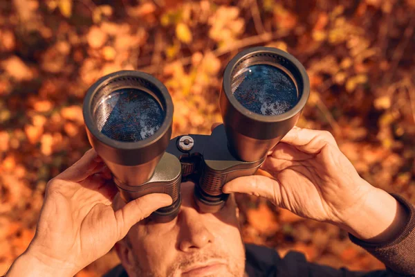 Kuşları ve diğer hayvanları dürbünle gözlemleyen amatör kuş gözlemcisi..