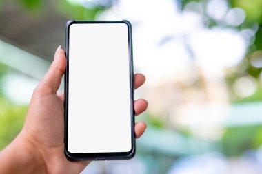 Eller beyaz bir ekran ve bokeh sahne ile bir telefon tutarak