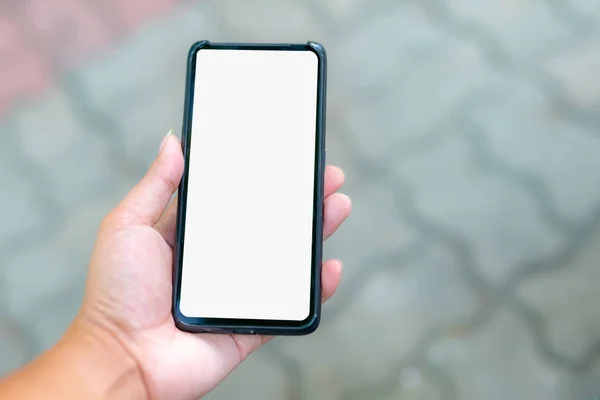 Eller beyaz bir ekran ve bokeh sahne ile bir telefon tutarak