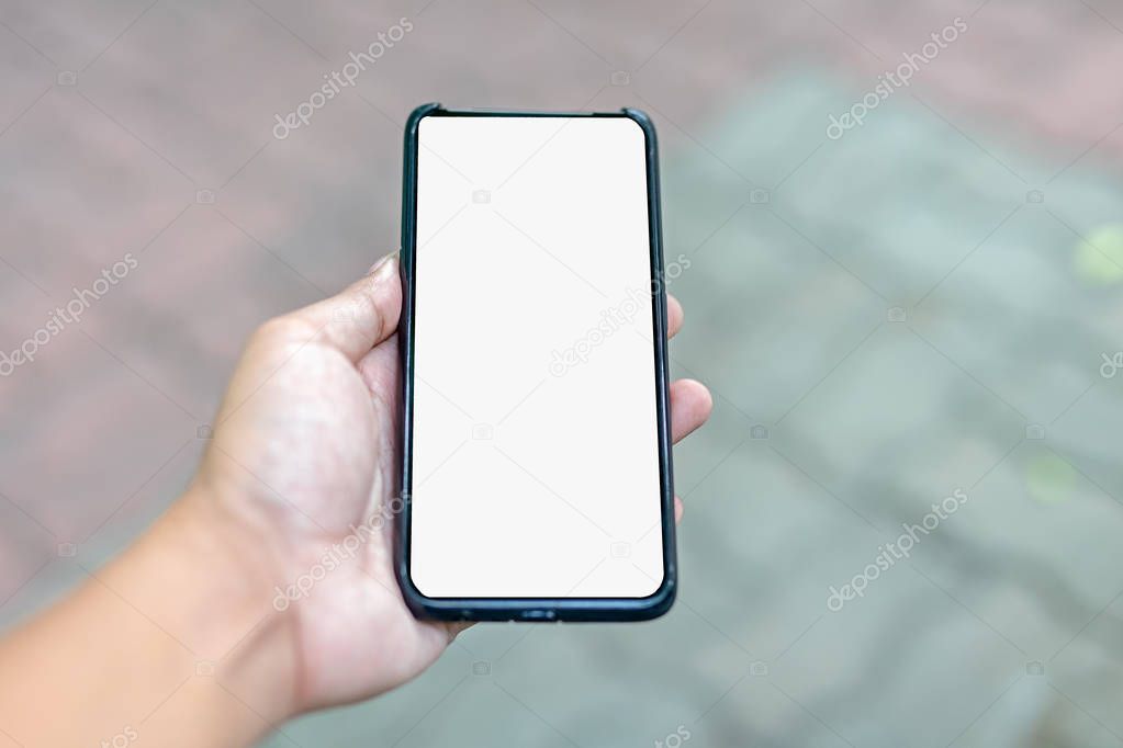 Hands holding a phone with a white screen and a bokeh scene