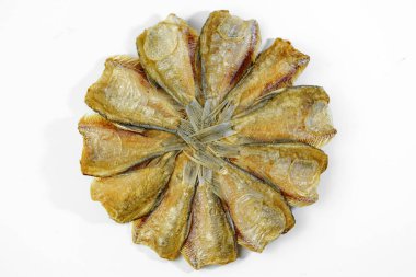 Kurutulmuş Kradi balığı, beyaz arka planda dairesel bir desen içinde kızartılmış.