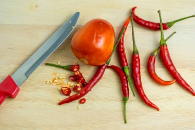 Ahşap kesim tahtası arka planında kırmızı domates ve kırmızı biber yakın çekim. Taze gıda malzemeleri kavramı.